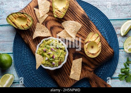 Top down view of fresh guacamole, served with tortilla chips. Stock Photo