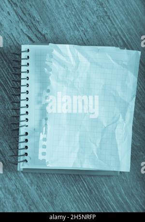 Empty crumpled pages and notebook lying on wooden surface Stock Photo