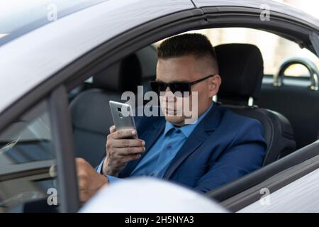 transportation and vehicle concept man using phone while driving car Stock Photo