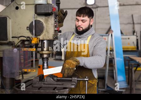 Man mechanic using drilling machine in workshop Stock Photo