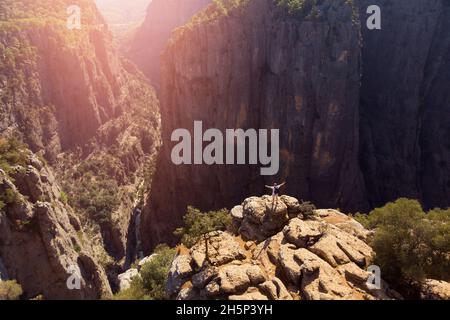 Man traveler standing on cliff of Tazi canyon Turkey with forest aerial top view drone with sunset. Concept travel lifestyle adventure freedom alone. Stock Photo
