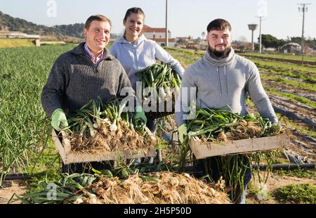 Happy farm family with freshly harvested scallions Stock Photo