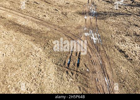 country dirt road in winter time. rural landscape with traces of cars on the ground. aerial view Stock Photo