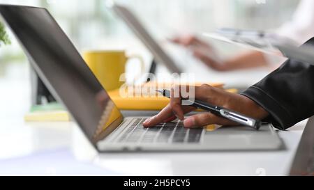 Cropped and closeup image of Businesswomen hands typing, using, working on laptop computer at office Stock Photo