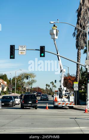 City worker using a lift to repair a street light in West Los Angeles, California Stock Photo