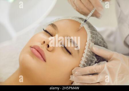 Beautician make botox facial injection to woman client Stock Photo