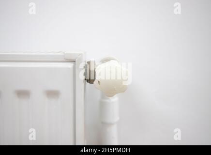 closeup heater radiator valve on white wall Stock Photo
