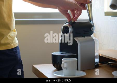 Unrecognizable man preparing coffee in a coffee machine with capsules. Stock Photo