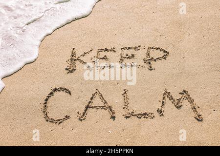 Keep calm written in the sand seashore of tropical beach Stock Photo