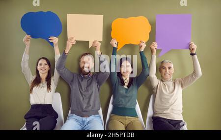 Group of happy people holding up blank mockup speech balloons and message bubbles Stock Photo