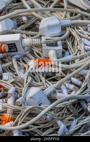 large amount of tangled and knotted electrical cables and wires in a box, tangled electrical cables, electric wiring in a mess, plugs and switches. Stock Photo