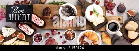 French desserts assortment on gray background. Traditional cuisine concept.Bon appetit lettering.Top view, flat lay, panorama Stock Photo