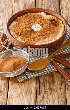 Risengrod which is rice pudding or porridge Danish Christmas food close up in the bowl on the table. Vertical Stock Photo