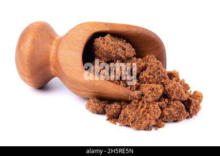 Muscovado sugar in wooden scoop, isolated on white background. Barbados sugar, khandsari or khand Stock Photo