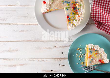 Rainbow layer cake on white wooden table Stock Photo