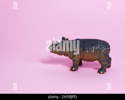 Rhino plastic model toy on pink background. Copy space. Stock Photo