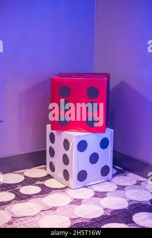 Vertical shot of red and white decorative dices in a room corner. Stock Photo