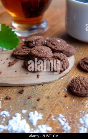 Vertical shot of dry chocolate cupcakes and a cup of coffee on a wooden table Stock Photo