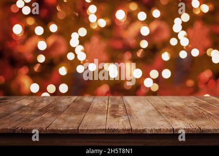 Empty wooden, rustic table with Christmas tree lights, bokeh in background Stock Photo