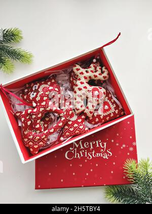 Red gift box with handmade Christmas baubles and text Merry Christmas Stock Photo