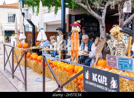 People sitting at  NC Cafe, Saintes Maries de la Mer, Camargue, France surrounded by halloween decorations Stock Photo