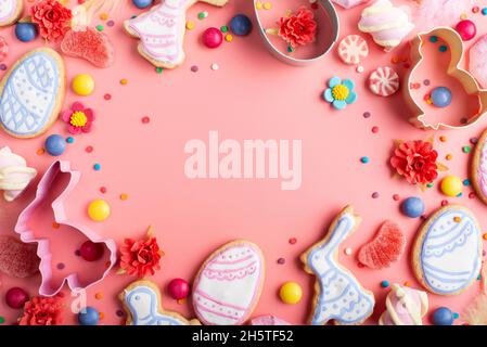 Easter cookies candies sugar sprinkles and cutters on pink background. Space for text Stock Photo