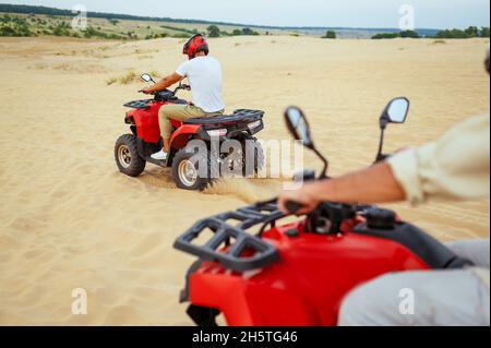 Two travelers in helmets, atv riding in desert Stock Photo