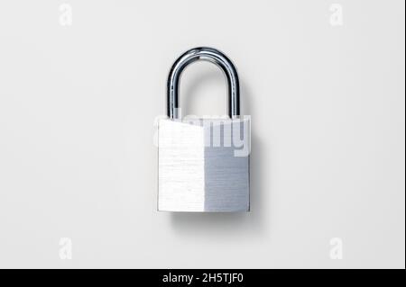 Security, lock or theft protection concept. Shiny, nickel-plated solid brass padlock against white background. Table top view, flat lay, copy space. Stock Photo
