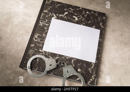 Top view of a folder with documents and handcuffs on the table, punishment concept, template for designers Stock Photo