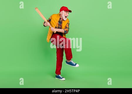 Photo of handsome funky senior gentleman wear yellow vest holding batter looking empty space smiling isolated green color background Stock Photo