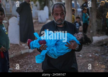 Broma, Syria. 11th Nov, 2021. A relative carries the body of the 1-year-old baby girl Marwa Khader, one of the victims of an aerial bombardment, carried out by Russian warplanes on the Broma village in Idlib Governorate. At least five civilians, including three children, were killed on Thursday in Russian airstrikes on a rebel stronghold in Syria, a monitoring group reported. Credit: Anas Alkharboutli/dpa/Alamy Live News Stock Photo