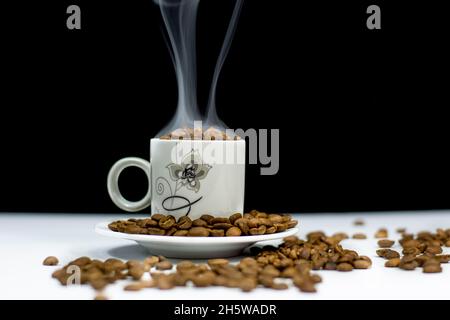 coffee cup and grains of coffee on white table Stock Photo