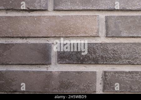 Detail of a wall made of facing bricks on the outside that form small interlocking pieces with gaps between them Stock Photo