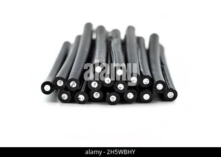 A stack of cut fiber optic cables lying on top of each other, isolated on a white background. Stock Photo