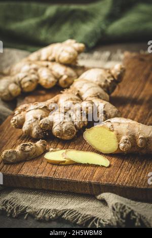 Fresh ginger on a wooden board, vertical Stock Photo