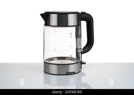 Glass, electric, modern transparent kettle on a white background. Close-up. Stock Photo