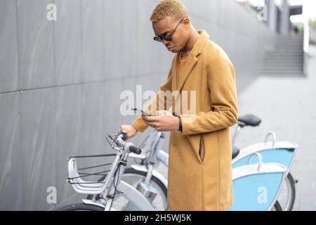 Man using smartphone app for bike rent Stock Photo