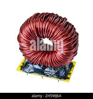 Toroidal inductor with red copper wire isolated on a white background. One ferrite core coil with black epoxy resin on yellow holder. Electrotechnics. Stock Photo