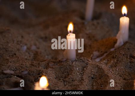 Candle light. Candles light in dark background. Candle flames in catholic church. Bokeh effect. Meditating, religion, holiday, hope, christmas, celebr Stock Photo