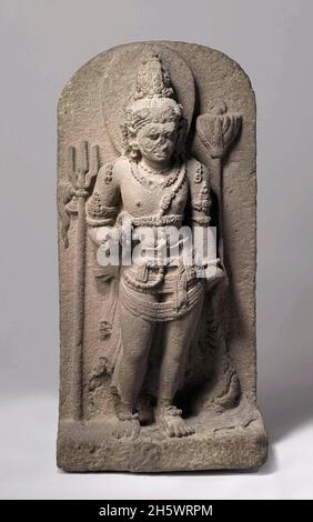 Nandishvara, one of the two guards at the entrance to temples of the Hindu god Shiva. He has the appearance of an elegant young man and stands on Shiva's right side. In one hand he holds a circle of prayer beads, in the other a floating lotus flower. The trident is the weapon of Shiva. Stock Photo