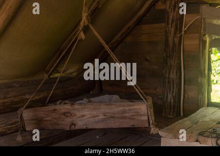 antique cradle for babies in an old hut. Stock Photo