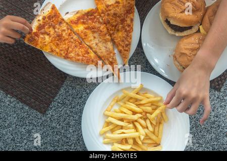 pizza, hamburger, fries on the table at a children's party. fast food. Stock Photo