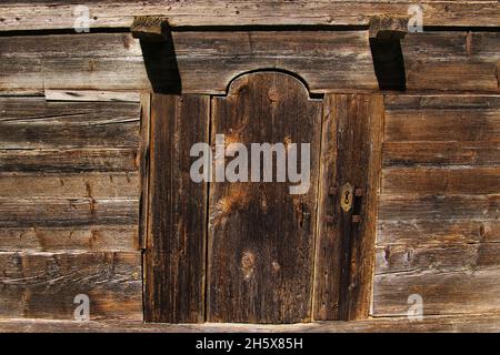 Old, weathered wooden door in a traditional barn in the French Alps, at least 200 years old. Stock Photo