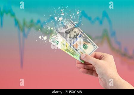 Inflation, hyperinflation, stagflation. One hundred dollar and one hundred euro banknotes splatter on the falling red graph. The concept of inflation Stock Photo