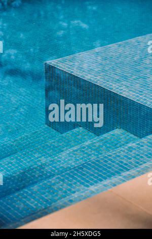 From above of tiled bottom and steps in swimming pool with clean blue water Stock Photo