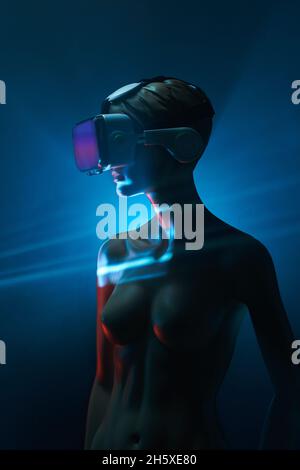 Dummy of Woman in futuristic VR goggles placed under bright projection in dim room Stock Photo