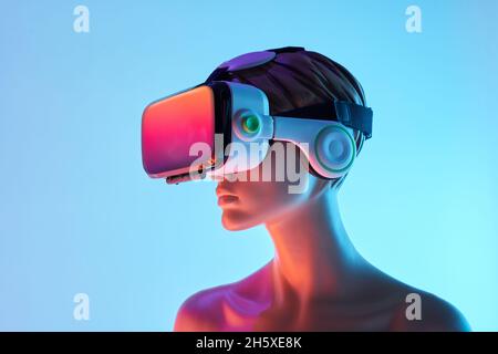 Female dummy with VR goggles placed against bright blue background as symbol of futuristic technology Stock Photo