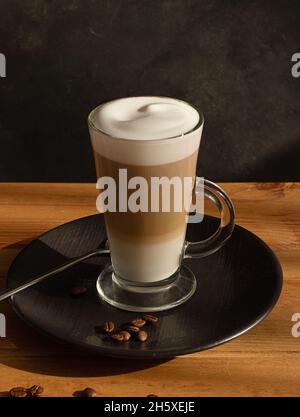 Glass of fresh hot aromatic latte coffee served on table Stock Photo
