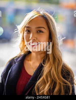 Closeup portrait of a young smiling Filipina woman in fall wardrobe Stock Photo