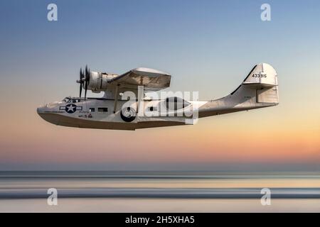 A Catalina flying boat aircraft photographed with a background of a flat calm ocean at sunset. This aircraft saw service in World War Two with the RCA Stock Photo